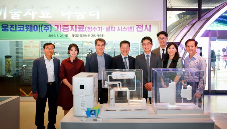김형권 웅진코웨이 마케팅전략부문장(왼쪽 다섯 번째)과 임승철 국립중앙과학관 관장 직무대리(왼쪽 네 번째)가 '시루직수' 정수기 제품들과 함께 기념촬영을 하고 있다.