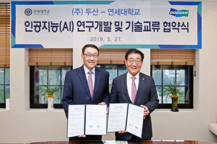27일 서대문구 연세대학교 언더우드관에서 열린 '두산-연세대 AI 연구개발 및 기술교류 협약식'에서 이현순 두산 부회장(왼쪽)과 김용학 연세대 총장이 MOU를 체결한 뒤 기념촬영을 하고 있다.