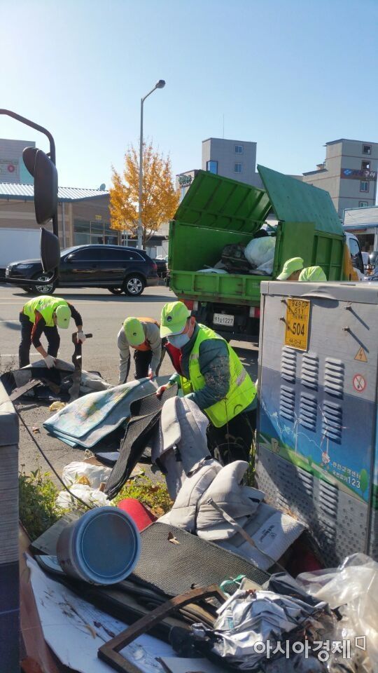 광주광역시 서구 환경관리원들이 불법 투기된 쓰레기를 치우고 있다.