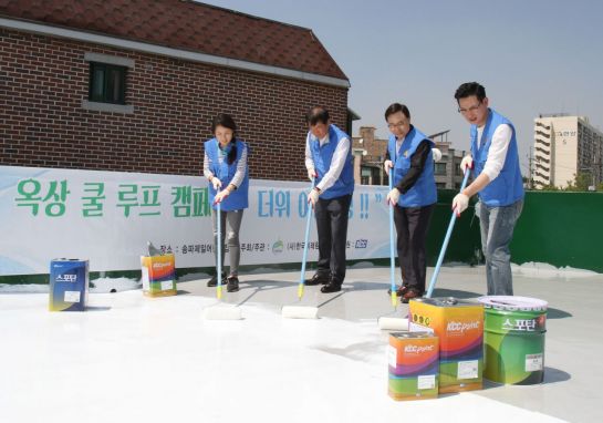 KCC 자원봉사자 등이 서울 송파제일어린이집 건물 옥상에서 고기능성 차열 페인트를 도장하며 봉사활동을 하고 있다.