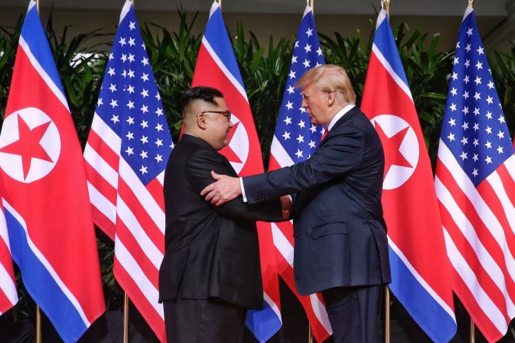 지난해 6월 12일 도널드 트럼프 미국 대통령과 김정은 북한 국무위원장이 싱가포르 센토사 섬 카펠라호텔에서 만나 인사하고 있다.