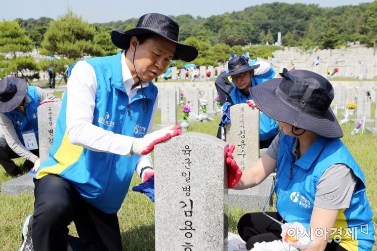 진옥동 신한은행장(왼쪽) 12일 서울시 동작구 국립서울현충원에서 임직원들과 순국선열의 묘비를 닦는 봉사활동을 하고 있다.