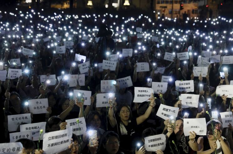 14일 홍콩에서 많은 어머니들이 '범죄인 인도 법안'(일명 송환법)을 반대하고 경찰의 과잉진압을 규탄하는 시위를 벌이며 휴대전화 불빛을 비추고 있다. 이들은 이날 시위에서 "우리 아이에게 쏘지 마라", "어머니는 강하다" 등의 구호를 외쳤다. <사진=AP연합>