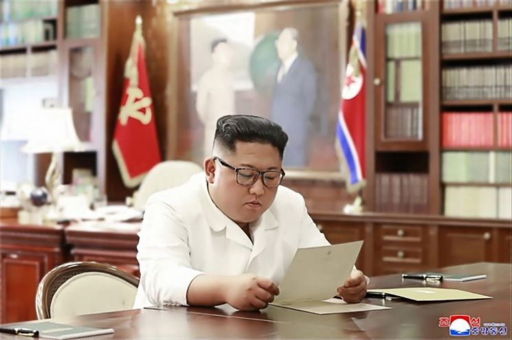 김정은 북한 국무위원장이 집무실로 보이는 공간에서 도널드 트럼프 미국 대통령의 친서를 읽는 모습을 담은 사진을 조선중앙통신이 23일 홈페이지에 공개했다.
