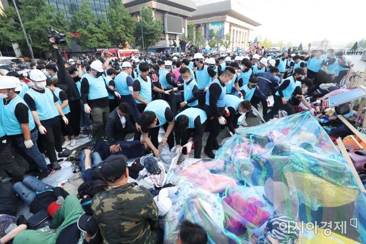 25일 서울 광화문광장에서 서울시 직원과 용역업체 관계자들이 대한애국당(우리공화당) 불법 천막을 철거하고 있는 가운데 당원과 지지자들이 거세게 저항하고 있다. /문호남 기자 munonam@