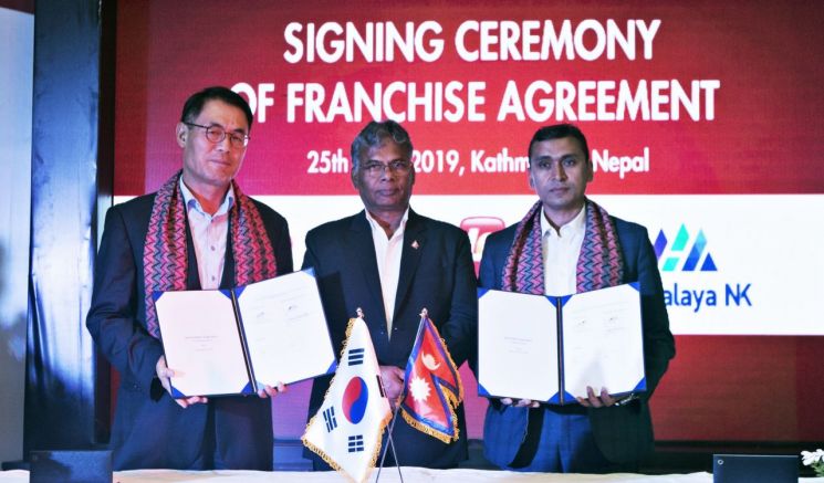 롯데GRS 남익우 대표(왼쪽)와 네팔 산업부 장관 마트리카 예다브(가운데)와 비너드 쿤워 회장이 프랜차이즈 계약 서명 후 기념 촬영에 임하고 있다.