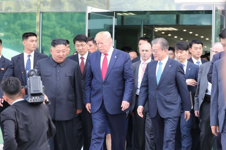 도널드 트럼프 미국 대통령, 김정은 북한 국무위원장이 30일 오후 판문점 남측 자유의 집에서 회동을 마친 뒤 문재인 대통령과 함께 군사분계선으로 이동하고 있다.