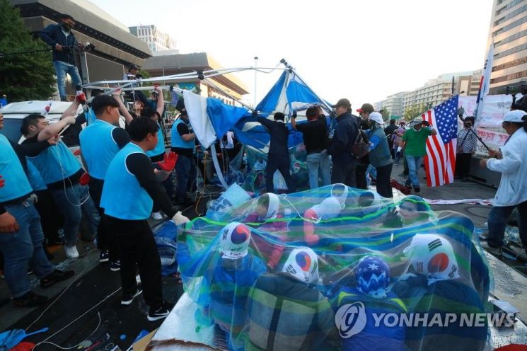 25일 오전 서울시 종로구 광화문 광장에서 농성 중이던 대한애국당(우리공화당) 천막을 서울시와 용역업체 관계자들이 철거하자 당원들이 저항하고 있다. 서울시는 오전 5시 20분부터 천막 2동 등 불법 설치물에 대한 행정대집행을 실시 중이다. 대한애국당은 24일 당명을 '우리공화당'으로 개정했다. [이미지출처=연합뉴스]