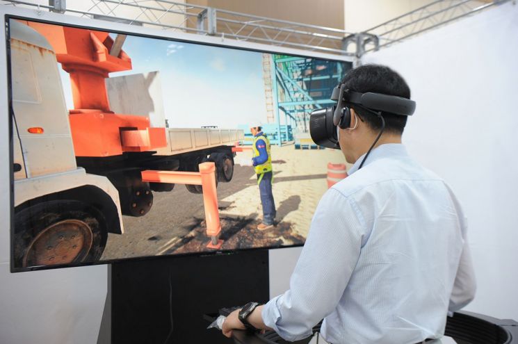 하석주 롯데건설 대표이사가 VR장비를 활용해 낙하물 사고 상황을 체험 중이다.