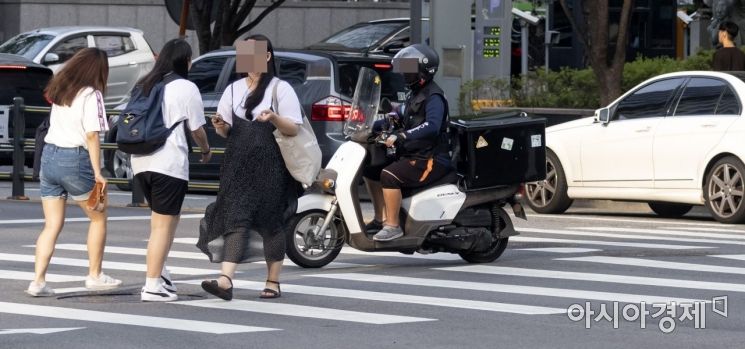 배달 오토바이가 보행자들과 같이 횡단보도를 이용해 길을 건너고 있다./윤동주 기자 doso7@