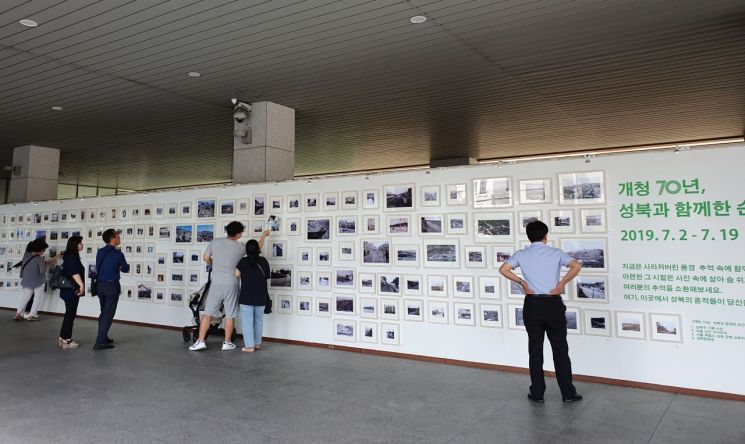 7월19일까지 성북구청 1층 로비에서 열리는 성북구 옛사진전에서 지나가는 시민들이 성북구의 옛모습을 보고 있다.