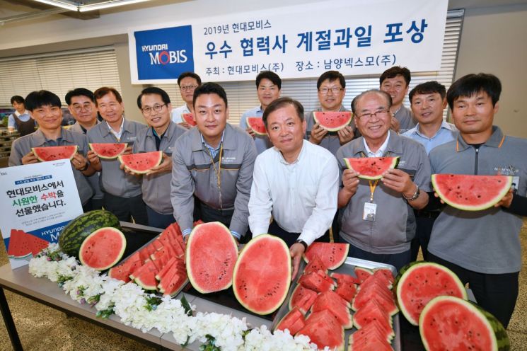 경기도 안산시 남양넥스모 대표와 직원들이 현대모비스가 전달한 수박을 들어보이며 활짝 웃고 있다. 현대모비스는 이달 말까지 AS순정 부품의 공급에 힘쓴 우수 협력사 250개사와 전국 1300여곳 대리점에 감사장과 함께 수박 1만여 통을 전달한다.