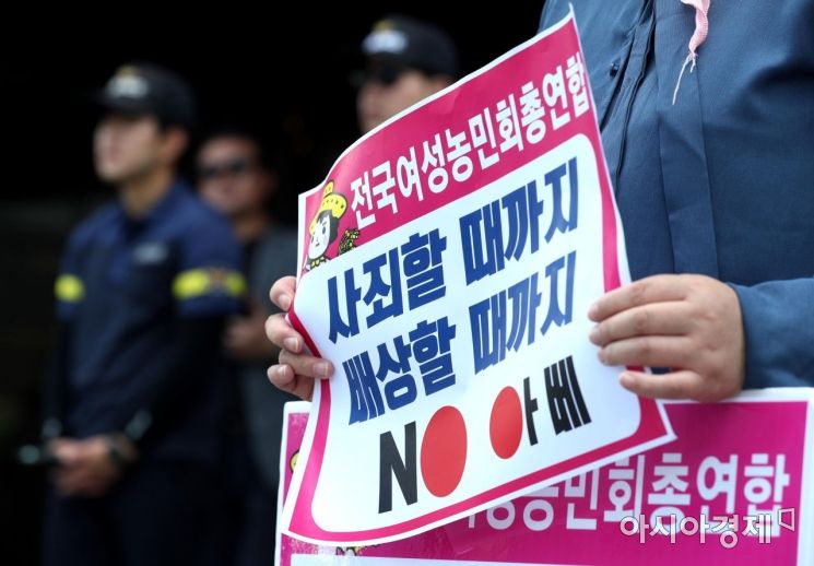 19일 서울 종로구 주한 일본대사관 앞에서 전국여성농민회총연합 관계자가 일본 정부를 규탄하는 피켓을 들고 있다. /문호남 기자 munonam@