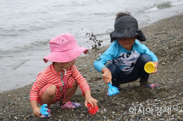 지난 24일 전남 여수 만성리 검은 모래 해변에서 아이들이 흙장난을 하면서 즐거운 시간을 보내고 있다.