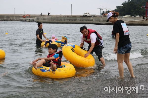 지난 24일 전남 여수 만성리 검은 모래 해수욕장에서 한 가족이 물놀이를 즐기고 있다.