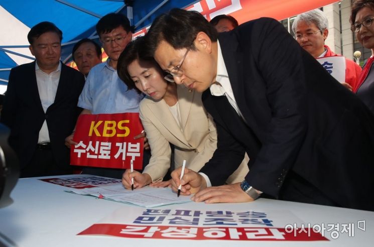 황교안 자유한국당 대표와 나경원 원내대표가 25일 KBS앞에서 열린 'KBS 수신료 거부를 위한 전국민서명운동'에 참석, 서명을 하고 있다./윤동주 기자 doso7@