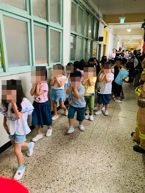 25일 서울 구로구의 한 초등학교에서 학생들이 코와 입을 가린 채 건물 밖으로 대피하고 있다/사진=연합뉴스