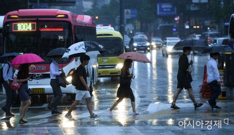 중부지방에 호우경보가 발령된 26일 서울 종로구 세종로 네거리 인근에서 직장인들이 우산을 쓴 채 출근길에 오르고 있다./강진형 기자aymsdream@
