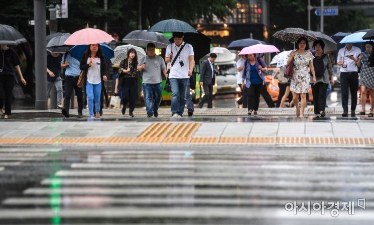 중부지방에 호우경보가 발령된 26일 서울 종로구 세종로 네거리 인근에서 직장인들이 우산을 쓴 채 출근길에 오르고 있다./강진형 기자aymsdream@
