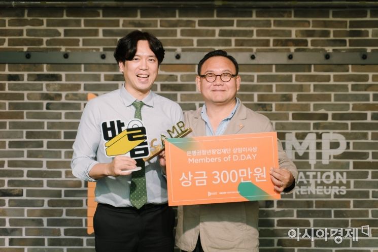 25일 은행권청년창업재단(디캠프)이 개최한 디데이에서 공동우승을 차지한 전성국 딕션 대표(왼쪽)가 김홍일 디캠프 상임이사와 기념촬영을 하고 있다.