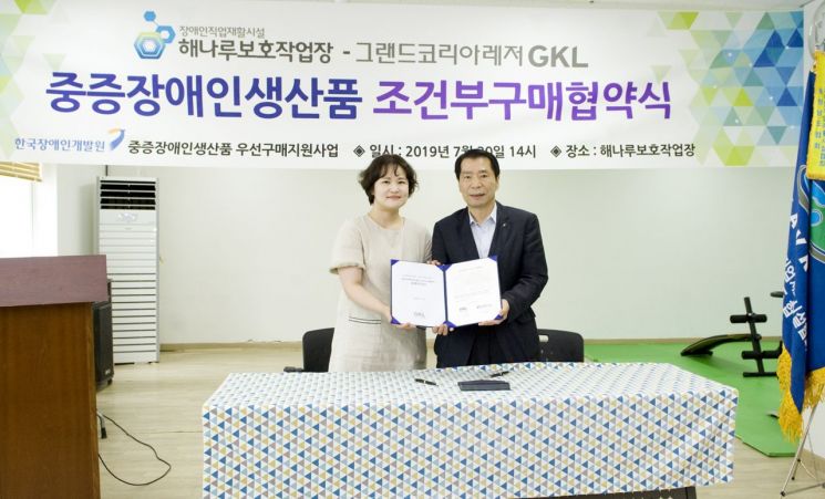 이형호 GKL혁신경영본부장(오른쪽)과 박정욱 해나루보호작업장 원장이 협약을 체결한 뒤 기념촬영하고 있다.[사진=GKL 제공]