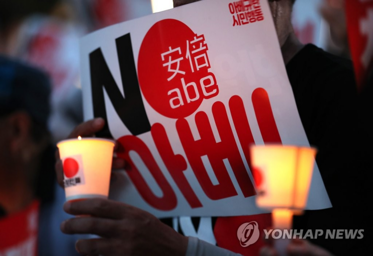 10일 오후 서울 종로구 옛 주한 일본대사관 앞에서 열린 '아베규탄 4차 촛불문화제'에서 참가자들이 촛불을 들고 있다.