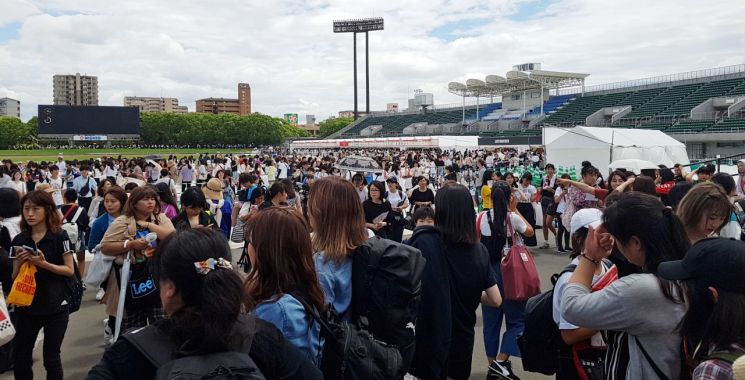 BTS 일본 스타디움 투어 첫날 공연이 펼쳐진 지난달 6일  일본 오사카 '얀마 스타디움 나가이' 앞 운동장에 마련된 BTS 굿즈(기념품) 판매장 주변이 기념품을 사려는 팬들로 붐비고 있다.<이미지출처:연합뉴스>