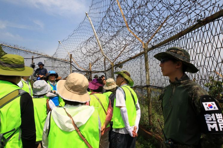강원 고성 DMZ 평화의 길 방문객들이 해안 철책에서 안내해설사의 설명에 귀를 기울이고 있다.[이미지출처=연합뉴스]