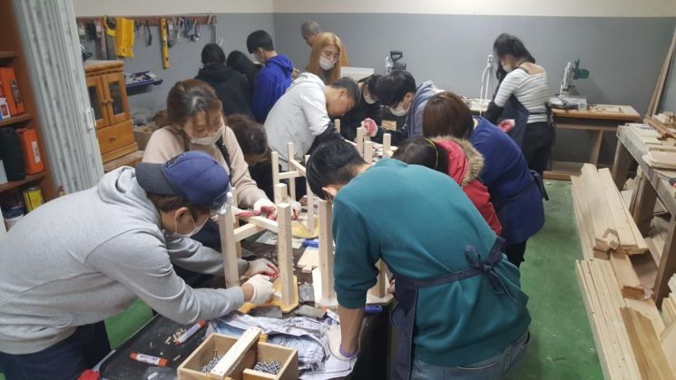 성북동아에코빌아파트 DIY공방 회원들이 의자를 만들고 있다.