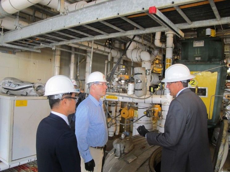 ▲존 믈리나 美미시건주 하원의원(가운데)이 스티브 퍼사인 SKSA 공장장(오른쪽)으로부터 PVDC 생산 공정에 대한 설명을 듣고 있다. 왼쪽은 김종현 SK종합화학 미국법인 대표.