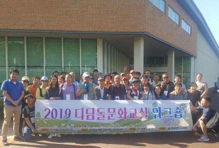 29일부터 1박2일간 진행된 '디딤돌 문화교실' 워크숍에 참석한 쪽방 주민 및 관계자들이 서울시서천연수원 앞에서 기념사진을 촬영하고 있다.