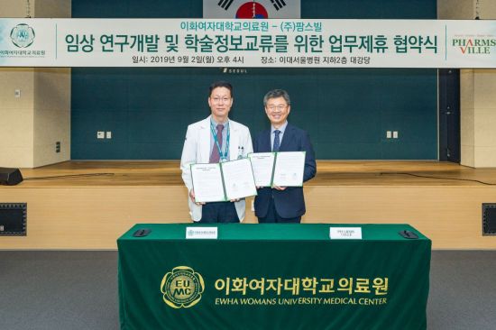 편욱범 이대서울병원장과 이병욱 팜스빌 대표가 협약서에 서명을 한 후 기념사진을 촬영하고 있다.
