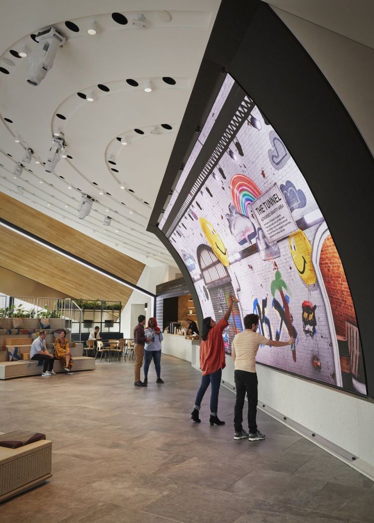 영국 런던에 있는 쇼핑몰 '콜 드롭스 야드'에 위치한 '삼성 킹스크로스'에서 관람객들이 초대형 커브드 LED 스크린에 직접 그림을 그리고 있다.