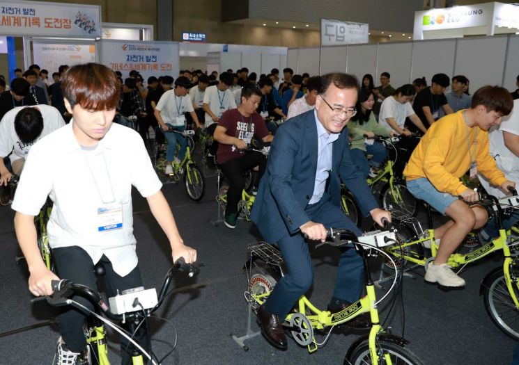 이상홍 한국에너지공단 부이사장(가운데)과 참관객들이 '자전거 발전 기네스 및 세계기록도전' 프로그램에서 자전거 발전기 패달을 밟으며 세계기록에 도전하고 있다.