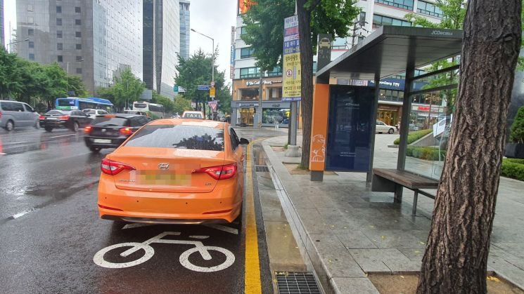 자전거우선도로 위에 설치된 택시 승강장. 택시 1대가 자전거 통행로를 가로막고 있다. /사진=이정윤 기자