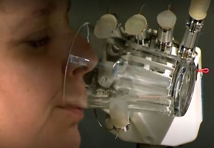 로봇 손을 단 장애인이 차가운 물 마시는 모습. 로봇 손에 장착된 전자피부로 인해 로봇 손을 통해 촉감을 느낄 수 있습니다. [사진=유튜브 화면캡처]