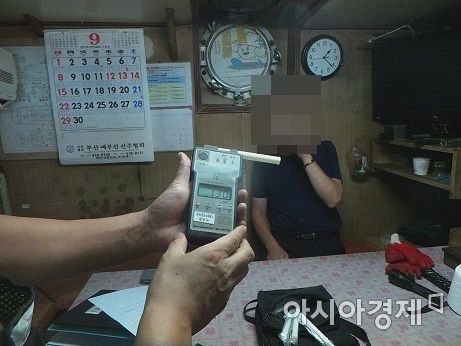 전남 여수해경이 19일 술에 취해 운항한 예인선 선장을 붙잡아 음주측정을 하고 있다.(사진=여수해경 제공)