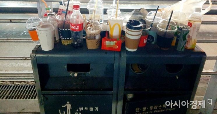 서울의 한 번화가에 비치된 쓰레기 분리수거함 위에 먹다 버린 커피가 담긴 플라스틱 커피 용기 등 쓰레기들이 어지럽게 널부러져 있다. 사진=한승곤 기자 hsg@asiae.co.kr