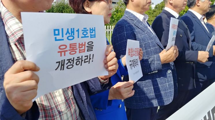 19일 서울 여의도 국회 앞에서 열린 '한국중소상공인총연맹 결성 기자회견'에서 중소상인·자영업자들이 유통산업발전법 개정을 촉구하는 팻말을 들어보이고 있다.