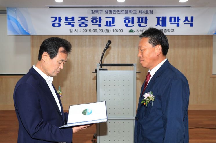 박겸수 강북구청장(왼쪽)이 김정철 강북중학교장(오른쪽)에게 교육 수료증을 전달하고 있다.