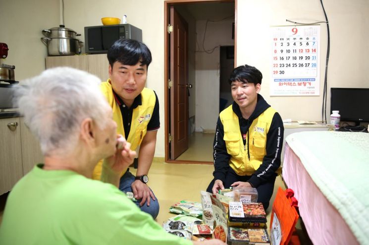 아워홈 봉사단원들이 독거 시각장애인 가정을 방문해 기프트백을 전달하는 모습
