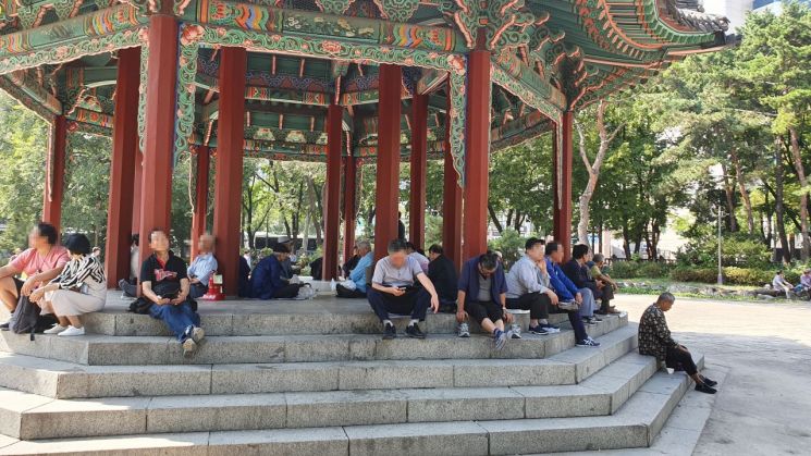 지난달 30일 서울 종로구 탑골공원에 모여있는 노인들이 이야기를 나누거나 스마트폰을 보며 시간을 보내고 있다./이정윤 기자