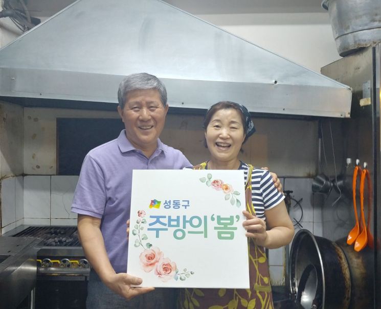 옥수동 ‘장군갈비’를 운영하고 있는 부부가 ‘주방의봄’ 사업 지원을 받아 후드를 청소하고 나서 환하게 웃고 있다.