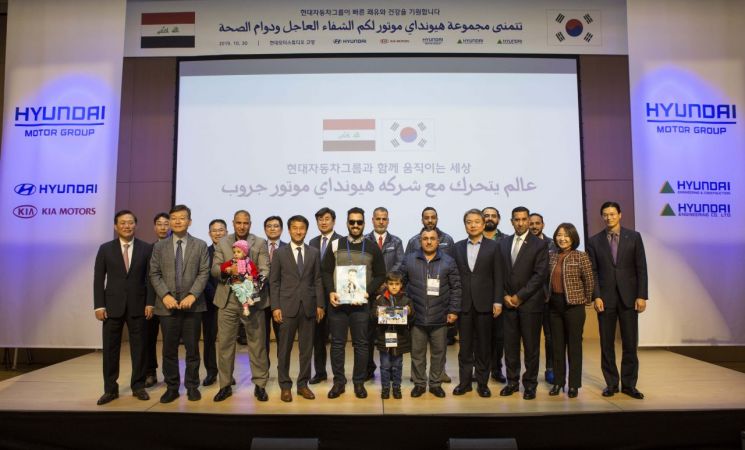 정진행 현대건설 부회장(앞줄 오른쪽 네 번째)과 한병도 이라크 특임 외교특별보좌관(앞줄 왼쪽 네 번째) 등이 이라크에서 온 환아 및 보호자, 국영방송 취재진 등과 기념촬영을 하고 있다. (제공=현대차그룹)