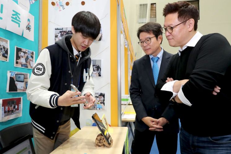 정원오 성동구청장(가운데)이 미국 로봇공학자 데니스홍 교수(오른쪽)와 함께 청소년 연구원들의 4차산업기술 기반 아이디어를 살펴보고 있다.