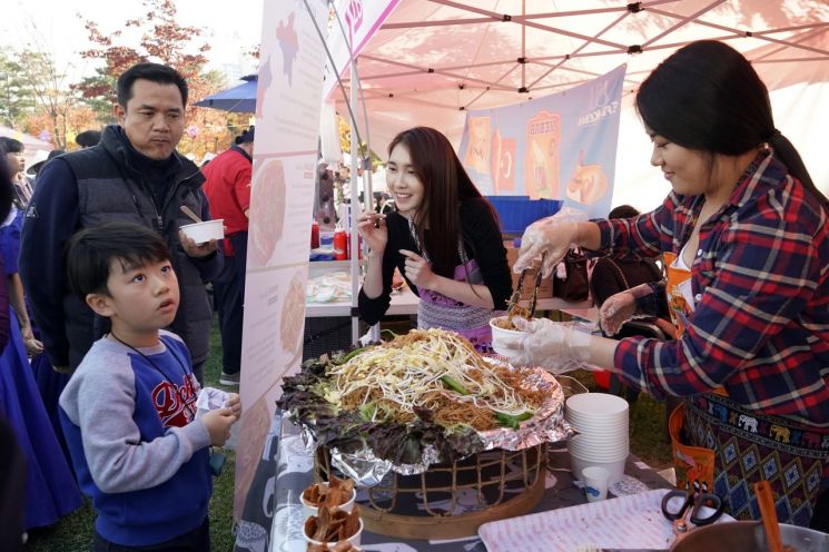 지난해 열린 ‘제10회 다문화 어울림 한마당-세계문화축제’에 마련된 음식부스에서 행사장을 찾은 어린이가 주문할 음식을 고르고 있다.