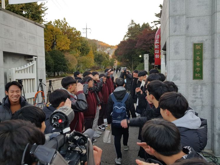 14일 서울 용산구 용산고등학교 앞 중앙고등학교 후배들이 시험장으로 들어서는 선배를 응원하고 있다.