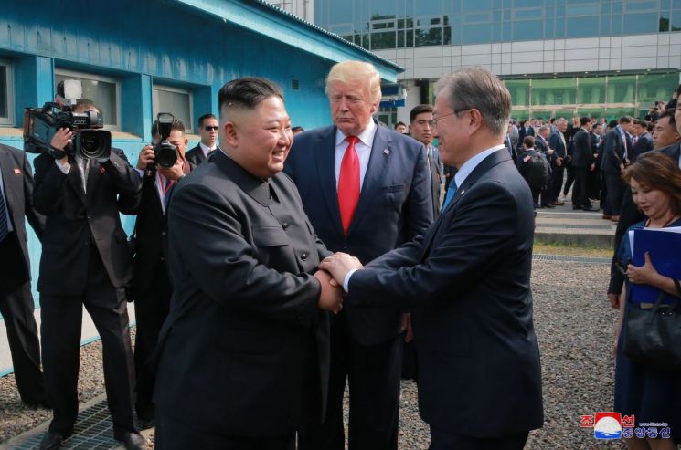 문재인 대통령과 김정은 북한 국무위원장이 지난 6월 30일 오후 판문점에서 두손을 맞잡고 대화하고 있다. 가운데는 도널드 트럼프 미국 대통령.