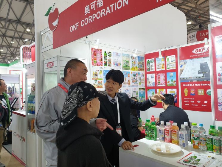 지난 13일 중국 상하이에서 열린 '2019 상하이 국제식품박람회' 한국관에 위치한 국내기업 오케이에프 부스에서 관람객들이 제품에 대한 설명을 듣고 있다./사진=우수연 기자