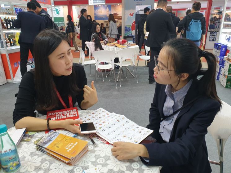 지난 13일 중국 상하이에서 열린 '2019 상하이 국제식품박람회'에서 박영림 KOTRA 상하이 무역관 대리(왼쪽)가 국내기업 착한떡을 중국 바이어에게 소개하고 있다./사진=우수연 기자